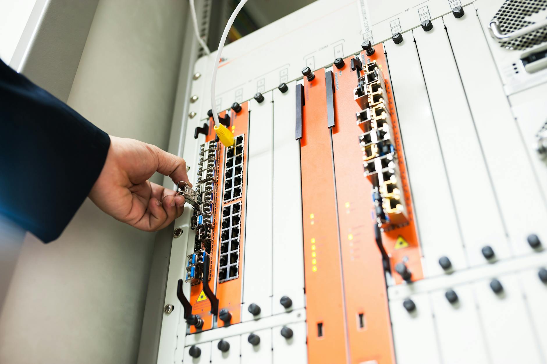 Kullanıcının ethernet kablosunu MikroTik switch portuna yerleştirme anı