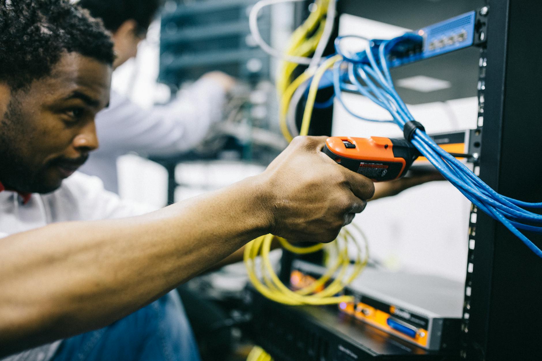 Hosting saglayicisinin sunucu kabini onunde MikroTik konfigurasyon yapan muhendis
